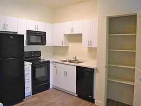 Midvale apartment for rent - Modern Kitchen with Black Appliances and White Cabinets at Kimpton Square Senior Apartments
