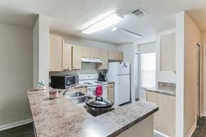 Sandersville apartment for rent - A kitchen with a granite countertop and white appliances.