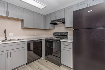 Phoenix apartment for rent - A kitchen with a black refrigerator and stove top oven.