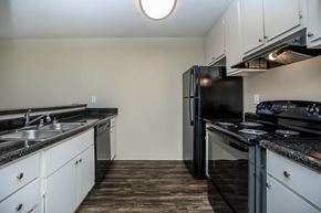 Bay Point apartment for rent - A kitchen with black appliances and white cabinets.