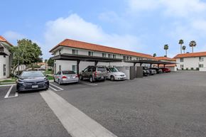 Palm Springs apartment for rent - A parking lot with cars and a building in the background.
