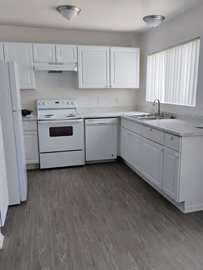 Winnetka townhouse for rent - A white kitchen with wood flooring and white appliances.
