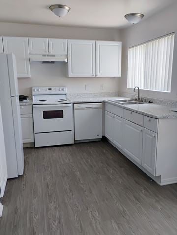 Winnetka townhouse for rent - A white kitchen with wood flooring and white appliances.