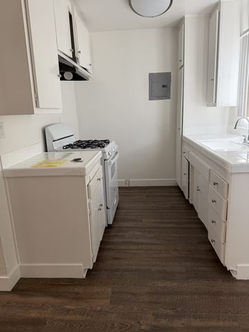 Sherman Oaks apartment for rent - A small white kitchen with a stove and sink.