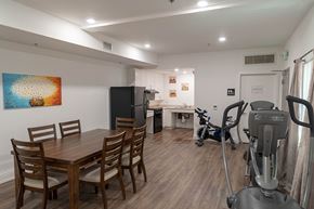 Huntington Park apartment for rent - A room with a dining table, chairs, a refrigerator, a kitchenette, and a treadmill.