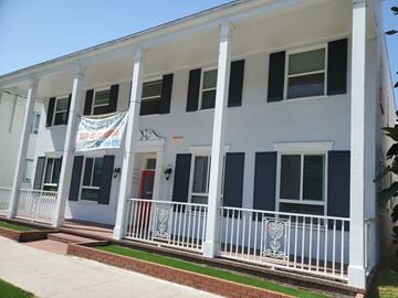 Long Beach apartment for rent - a white building with blue shutters and a banner on the front