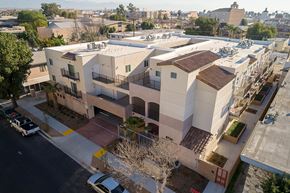 Huntington Park apartment for rent - A modern apartment complex with a parking lot in front.