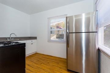 Long Beach apartment for rent - a kitchen with a stainless steel refrigerator and a window