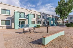 Phoenix apartment for rent - A row of apartment buildings with a bench in front of them.