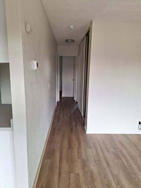 Coachella apartment for rent - a long hallway with white walls and wood floors