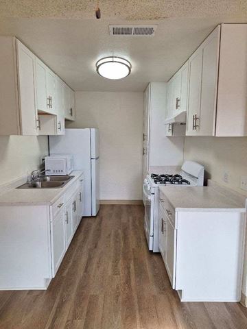 Coachella apartment for rent - an empty kitchen with white cabinets and white appliances