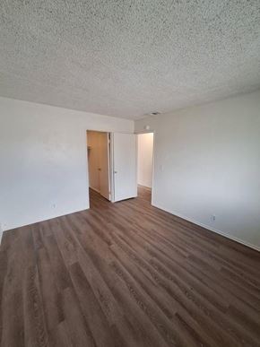 Coachella apartment for rent - an empty living room with white walls and wood floors