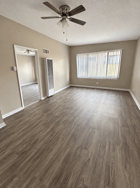Reseda apartment for rent - A room with a ceiling fan and wooden flooring.