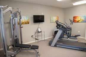 Live Oak apartment for rent - A home gym with a treadmill, a weight bench and a television.