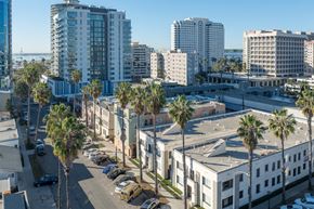 Long Beach apartment for rent - A view of a city street with palm trees and buildings.