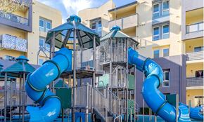 Gilroy apartment for rent - a playground with a blue spiraled slide in front of a building