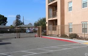 Oakland apartment for rent - A parking lot in front of a tan apartment building.