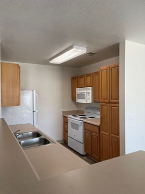 Globe apartment for rent - a small kitchen with white appliances and wooden cabinets