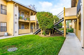 Sacramento apartment for rent - A yellow building with a green hedge on the side.