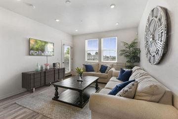 Morgan Hill apartment for rent - A living room with a large clock on the wall and a couch with blue pillows.
