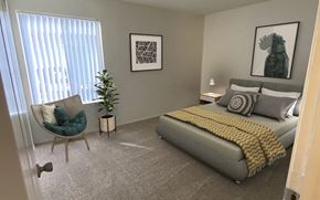 San Jose apartment for rent - A bedroom with a bed, chair, and two pictures on the wall.