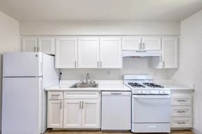 San Jose apartment for rent - A white kitchen with a refrigerator, sink, and stove.