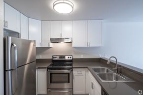 Redondo Beach apartment for rent - A modern kitchen with stainless steel appliances and white cabinets.