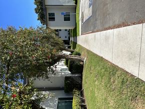 Oxnard apartment for rent - a view of the side of a building with an apple tree in front of it