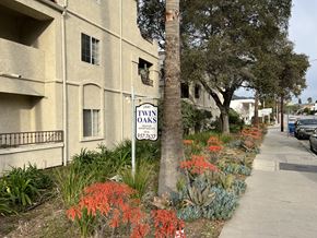 Verdugo City apartment for rent - A sign for the 23rd Twin Oaks apartment complex stands in front of a building.