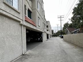 Verdugo City apartment for rent - A long concrete building with a garage door open.