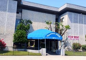 Winnetka townhouse for rent - A building with a blue umbrella and a for rent sign.