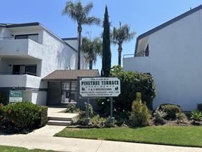 Reseda apartment for rent - a building with a sign in front of it with palm trees