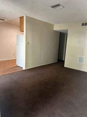 Bakersfield apartment for rent - an empty living room with wood flooring and white walls
