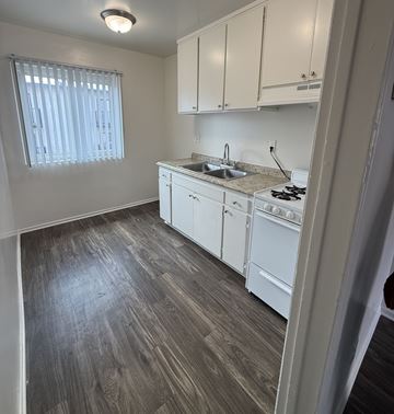 North Hollywood apartment for rent - A kitchen with white cabinets and a wooden floor.