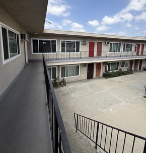 North Hollywood apartment for rent - A balcony with a black railing and a view of a building with red and white doors.