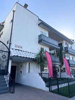 Winnetka apartment for rent - A white building with a black gate and a red banner.