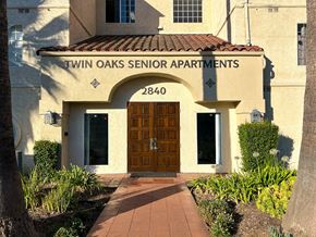 Verdugo City apartment for rent - The entrance to the Twin Oaks Senior Apartments is framed by plants and trees.