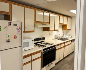 Verdugo City apartment for rent - A kitchen with a white fridge and black stove.