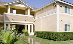 Jurupa Valley apartment for rent - A house with a well-manicured lawn and a potted plant.