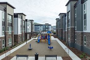 American Canyon apartment for rent - A playground area with a slide and swings is surrounded by apartment buildings.