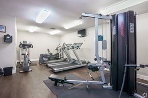 Pittsburg apartment for rent - A gym with a variety of equipment including a treadmill, a weight bench and a rowing machine.