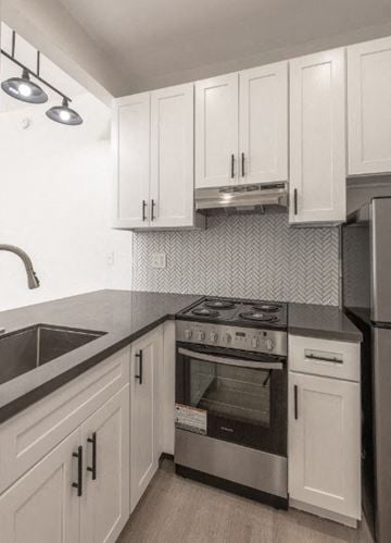 Los Angeles apartment for rent - a kitchen with white cabinets and a stove and a sink