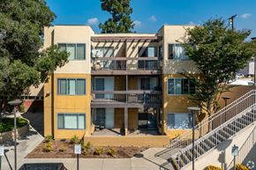 Monrovia apartment for rent - A yellow and beige apartment building with a staircase leading to the second floor at Oak Park Apartments, Monrovia, 91016