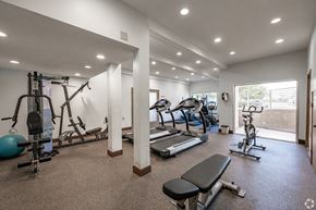 Monrovia apartment for rent - A spacious gym with a variety of equipment including treadmills, exercise bikes, and weight machines at Oak Park Apartments, Monrovia, 91016