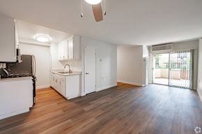 Monrovia apartment for rent - A kitchen with white cabinets and a wooden floor at Oak Park Apartments, Monrovia, 91016