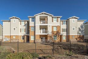 Folsom apartment for rent - A row of modern townhouses with balconies and a black fence in front.
