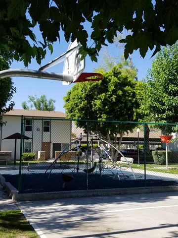 Palm Springs apartment for rent - a playground with a swing set in front of a building