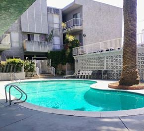 Winnetka townhouse for rent - A pool in front of a building with a palm tree.
