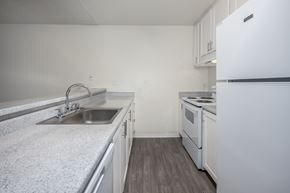 Sacramento apartment for rent - A kitchen with a white fridge, sink and stove.