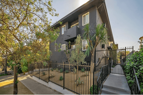 Los Angeles apartment for rent - A modern house with a black fence and a tree in front.